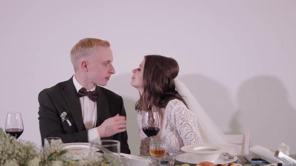 Caucasian Groom and Bride Drinking Champagne or Wine From Glasses Wedding Ceremony in Restaurant