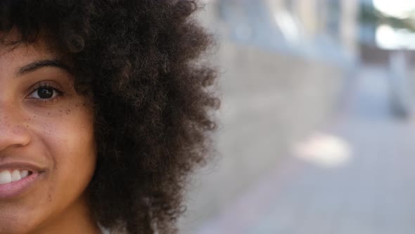 portrait of half a face of one young beautiful cheerful African or American woman looking