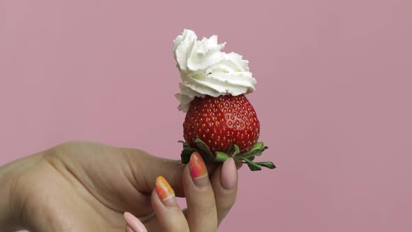 Woman Hand Holds Strawberry and Squeeze Out Whipped Cream on Top of the Berry