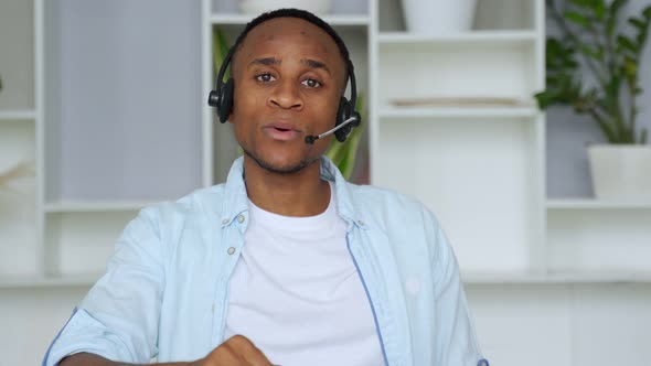 Smiling African Professional Call Center Operator Wear Wireless Headset Look at Camera, Afro