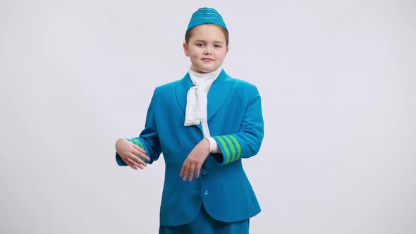 Nice Charming Caucasian Little Stewardess Showing Aside Smiling Looking at Camera Posing at White