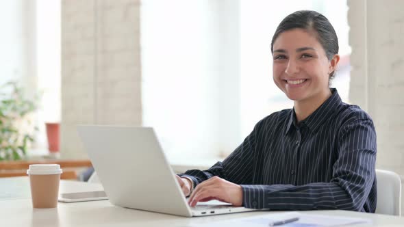 Cheerful Young Indian Woman with Laptop Smiling at Camera 
