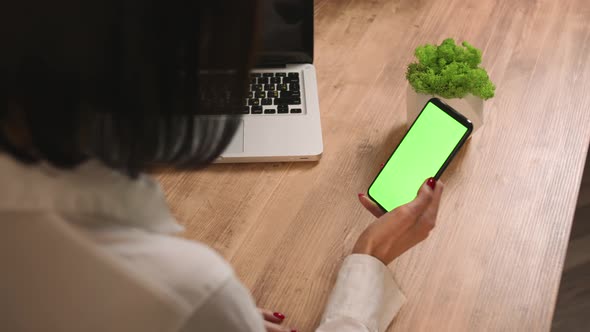 Back View of Woman Holding Smartphone Chromakey Green Screen Watching Content