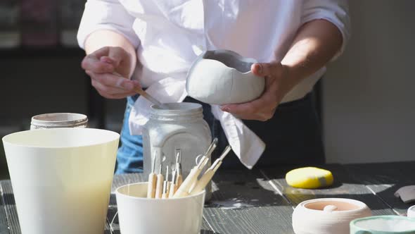 Production Process of Pottery. Application of Glaze Brush on Ceramic Ware.