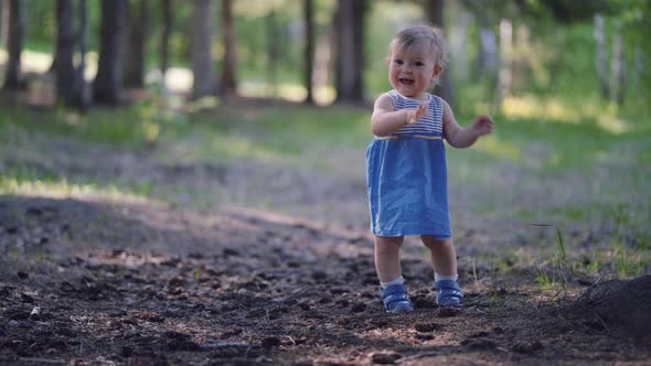 one year old baby learned to walk. little girl runs in the park alone