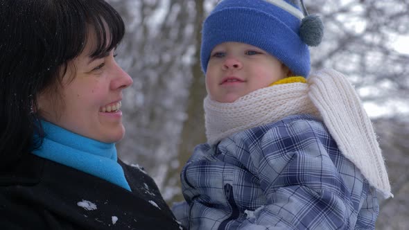 Happy Mother Smiles And Kises Her Little Child