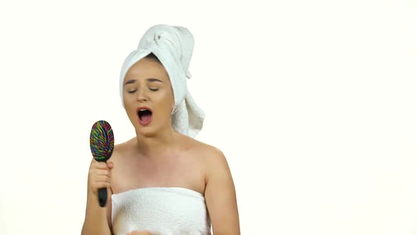 Girl in White Towel on Her Head Dance and Sing Into Comb As in Microphone Isolated on White