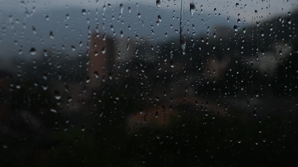 Raindrop falling through a window glass
