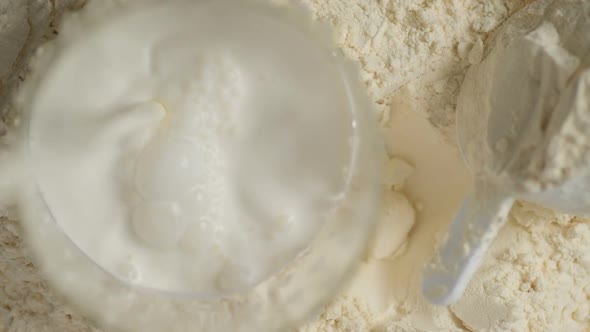 Protein powder and measuring scoop over the jar