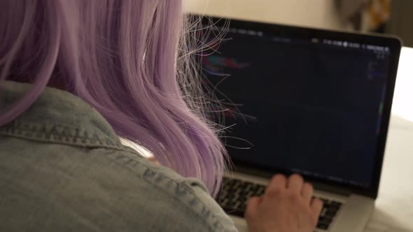 Woman developer coding on laptop computer on kitchen