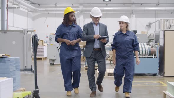 Team of Older Factory Engineer and Two Diverse Female Employees