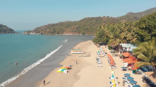 Aerial 4k drone footage of visitors enjoying a tropical beach of Palolem, India.