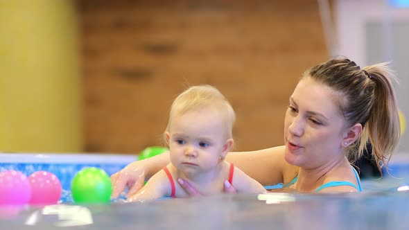 Little Girl with a Trainer in the Pool