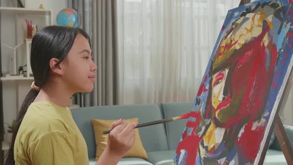 Asian Artist Girl Holding Paintbrush Thinking Before Painting A Girl's Hair On The Canvas