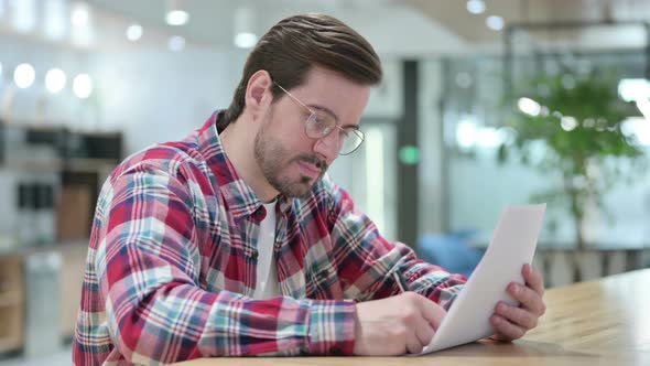 Hardworking Male Designer Reading Documents 