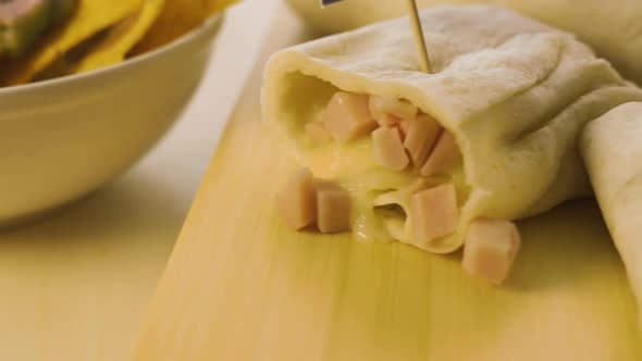 Close Up of a Hot Fresh Burrito and Nachos with Guacamole Cream.