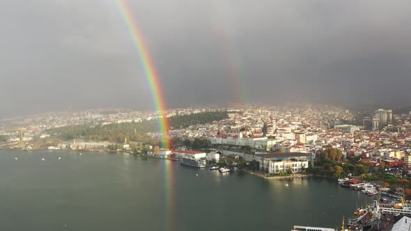 Wide aerial view of a real double rainbow over the Bosphorus River and European buildings on a cloud