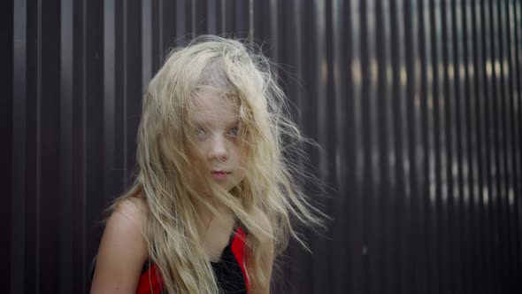 View of a little girl with blond tousled hair. A child neglected.