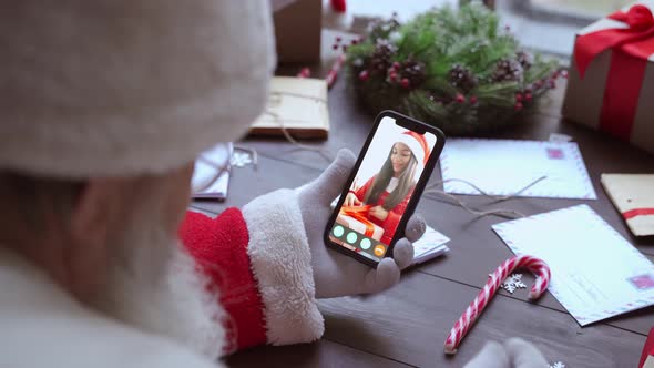 Santa Claus Talking to Child on Phone Video Call Open Present Sit at Table