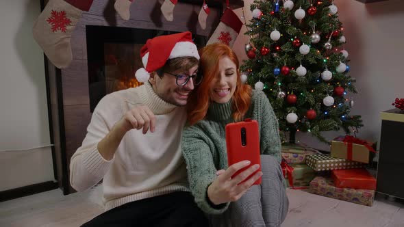 A man and a woman making selfie at Home in a Christmas atmosphere.