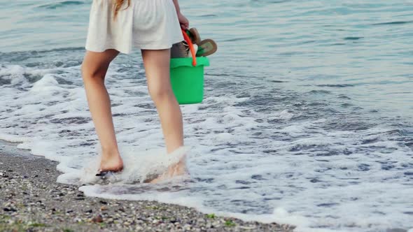 Legs of Young Woman Stepping on Sand