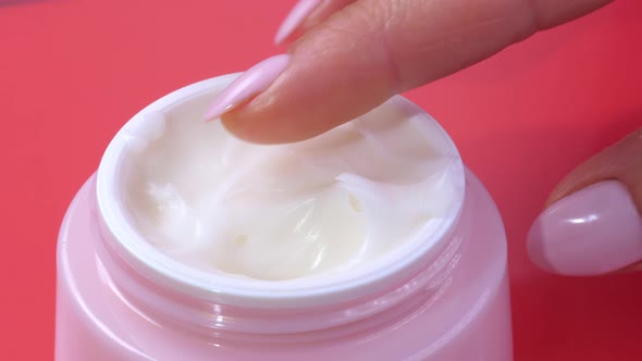 Woman Takes Finger Cream From a Pink Jar