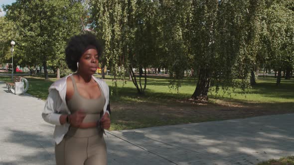 Plus Size African American Woman Jogging in Park