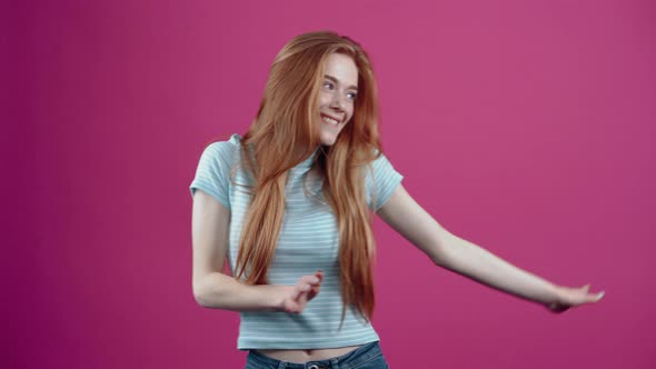 The Redhead Party Girl Moves to the Rhythm of the Music Improvising Dance Moves in a Blue Casual