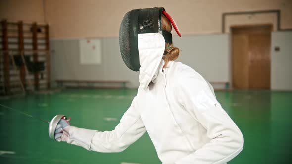 Two Young Women at Fencing Training in the Gym - a Ginger Woman Triumphs