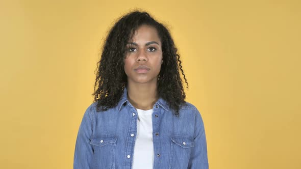 African Girl Looking at Camera Isolated on Yellow Background