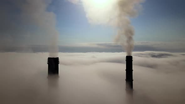 Coal Power Plant High Pipes Emitting Black Poisonous Smoke Moving Upwards Over White Fog Polluting