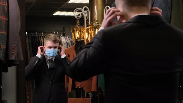 Man putting on a protective mask in front of a mirror