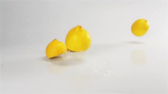 Lemons Fall Down at White Wet Surface