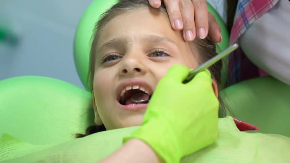 Mother Comforting Scared Little Girl During Dental Examination, Childrens Fears