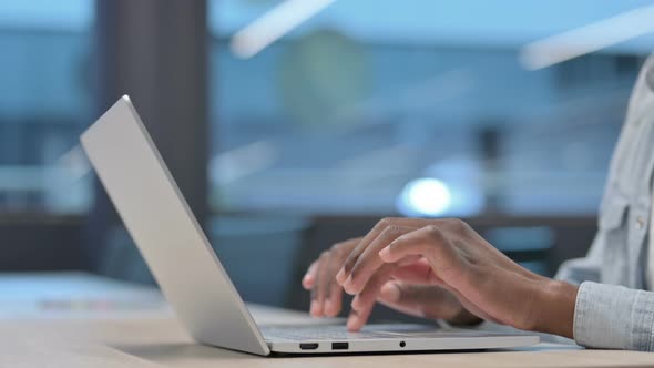 African Hands Typing on Laptop