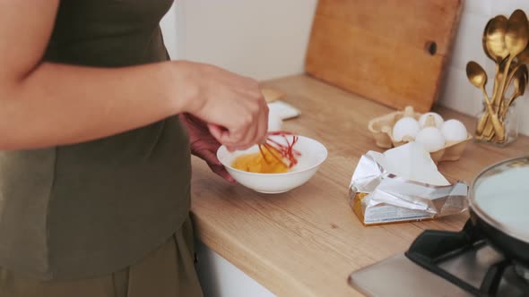 A woman hands making an omelet