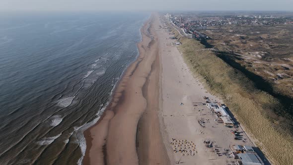 Drone Flies Over Ocean Shore Outside the City on a Sunny Day