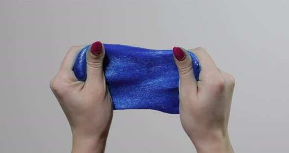 Woman Hands Playing with Oddly Satisfying Blue Slime Gooey Substance. Antistress