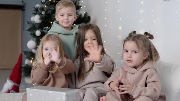 Children Showing Hi Near Christmas Tree