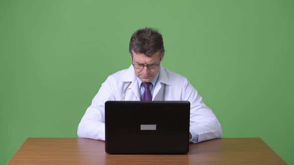 Mature Handsome Man Doctor Against Green Background