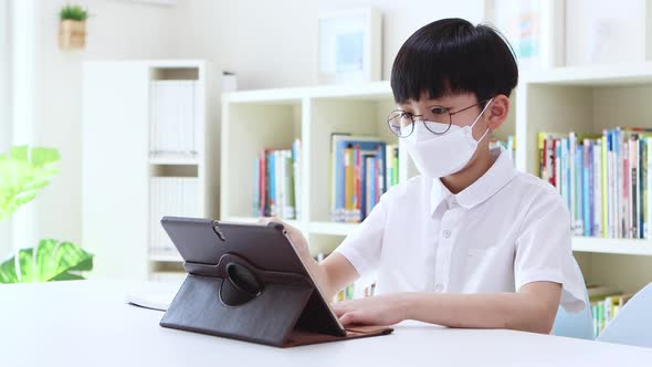 Boy in mask doing video lessons at home via internet online