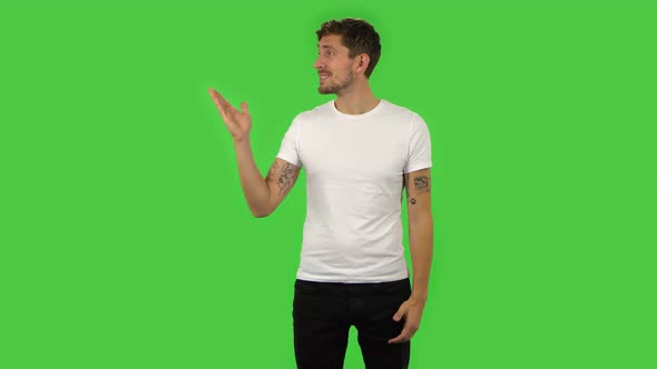 Confident Guy Is Talking and Pointing Side Hand for Something, Copy Space.. Green Screen