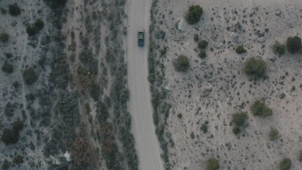 Drone shot of truck driving through desert. Drone shot of truck driving down dirt road. Vehicle driv