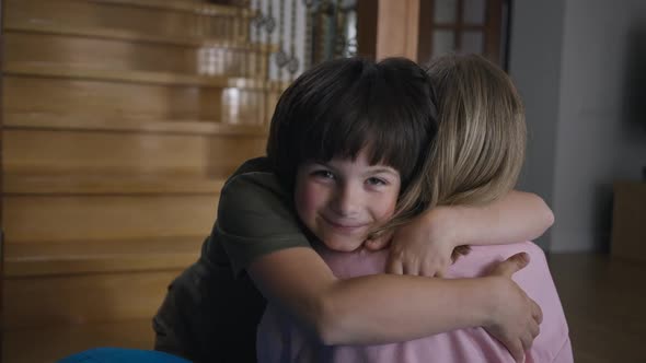 Happy Caucasian Little Boy Hugging Teenage Girl Looking at Camera Smiling