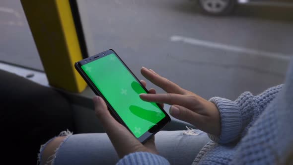 Woman's Hand Holding a Smartphone with a Green Screen in Tram. Chroma Key