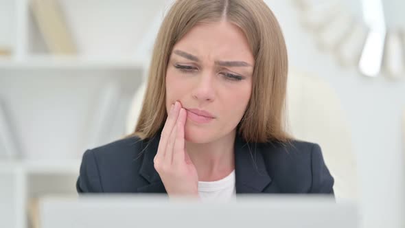 Young Businesswoman with Laptop Having Toothache