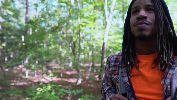 Content Young African American Man Standing in a Forest