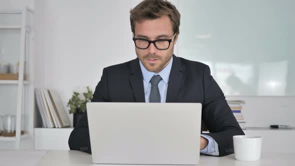 Businessman Working On Laptop in Office