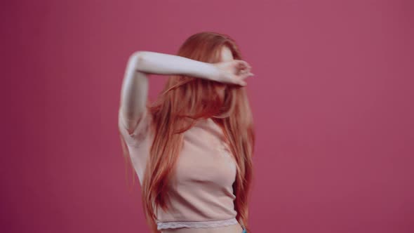 Happy Redhaired Young Woman Dancing Waving Her Hands with a Smile on Her Face