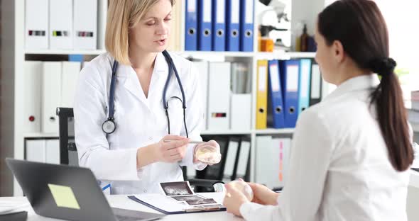 Mammologist Shows Silicone Breast Implant to Client